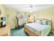 Comfortable bedroom with wood bed frame, neutral walls, and elliptical workout machine at 3287 Meadow Run Cir, Venice, FL 34293