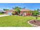 Charming single-story home featuring a manicured lawn and lush tropical landscaping at 3287 Meadow Run Cir, Venice, FL 34293