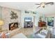 Living room with stone fireplace, vaulted ceilings, and access to the backyard at 3287 Meadow Run Cir, Venice, FL 34293
