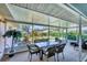 Relaxing sunroom with glass table and chairs overlooking the lush garden at 3287 Meadow Run Cir, Venice, FL 34293