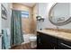 Charming bathroom with tiled shower, blue patterned shower curtain, and granite countertop vanity at 347 Portofino Dr, Punta Gorda, FL 33950