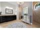 Well-lit bathroom featuring dark wood cabinets, granite countertops, walk-in shower, and decorative chandelier at 347 Portofino Dr, Punta Gorda, FL 33950