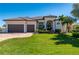 Beautiful home featuring a well-manicured lawn, a two-car garage, and lush tropical landscaping at 347 Portofino Dr, Punta Gorda, FL 33950