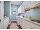 Organized laundry room with white cabinets, granite countertops, washer, dryer, and a drying rack at 347 Portofino Dr, Punta Gorda, FL 33950