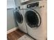 Modern laundry room features front load washer and dryer with wood look floor at 347 Portofino Dr, Punta Gorda, FL 33950