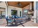 Covered outdoor kitchen with a grill, sink, stone accent wall, television, and comfortable lounge seating at 347 Portofino Dr, Punta Gorda, FL 33950