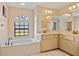 Lovely bathroom with double sinks, soaking tub, tiled floors and a window at 3614 January Ave, North Port, FL 34288
