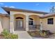 Inviting front porch with seating area, decorative columns, tiled flooring, and manicured landscaping at 3614 January Ave, North Port, FL 34288