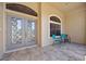 Close-up of the tiled front porch with seating area, decorative windows, and double door entry at 3614 January Ave, North Port, FL 34288