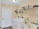 Bright laundry room with washer, dryer, sink, and shelving for ample storage at 3935 Nemo Ave, North Port, FL 34287