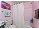 Bathroom showcases pink-tiled walls complemented by a shower and seashell-themed artwork at 4022 Beaver Ln # 500C, Port Charlotte, FL 33952