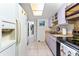 Galley kitchen with updated appliances, bright lighting, and easy access to other rooms at 4022 Beaver Ln # 500C, Port Charlotte, FL 33952