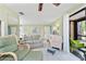 Bright living room featuring a ceiling fan, tile floors, and access to a screened lanai at 4022 Beaver Ln # 500C, Port Charlotte, FL 33952