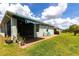 Large backyard with green grass, blue awning, and screened in porch at 5309 Shell Mound Cir, Punta Gorda, FL 33982