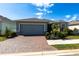 Beautiful single-story home with brick paved driveway, manicured lawn and tropical landscaping at 5309 Shell Mound Cir, Punta Gorda, FL 33982