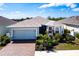 Charming single story home featuring manicured landscaping, paver driveway, attached two-car garage, and light blue paint at 5309 Shell Mound Cir, Punta Gorda, FL 33982
