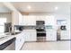 Bright kitchen featuring stainless steel appliances, white cabinetry, and a stylish tile backsplash at 5309 Shell Mound Cir, Punta Gorda, FL 33982