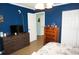 Bedroom with blue walls and tan tile flooring, featuring a dresser and closet at 6249 Drucker Cir, Port Charlotte, FL 33981