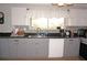 Kitchen featuring gray cabinets, dark countertops, modern appliances and window over sink at 6249 Drucker Cir, Port Charlotte, FL 33981