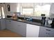 Kitchen featuring gray cabinets, dark countertops, modern appliances and window over sink at 6249 Drucker Cir, Port Charlotte, FL 33981