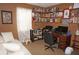Home office with wooden desk, shelving, and a comfortable sofa at 6249 Drucker Cir, Port Charlotte, FL 33981