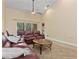 Open living room featuring leather sofas, ceiling fan, and access to a balcony with lush views at 7196 N Plum Tree # 323, Punta Gorda, FL 33955