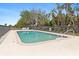 Relaxing community pool with comfortable lounge chairs and refreshing clear blue water surrounded by palm trees at 7196 N Plum Tree # 323, Punta Gorda, FL 33955