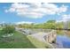 Wooden dock sits on the canal with a grassy lawn and blue skies overhead at 724 Blackburn Blvd, North Port, FL 34287