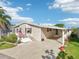 Charming home exterior with carport, front porch and well kept lawn at 724 Blackburn Blvd, North Port, FL 34287