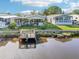 Waterfront home featuring a private dock and lush tropical landscaping at 724 Blackburn Blvd, North Port, FL 34287