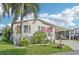 Charming home with covered parking, lush landscaping, and an American flag at 724 Blackburn Blvd, North Port, FL 34287