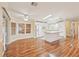 Open kitchen and dining area with white appliances, kitchen island, wood laminate flooring and bright lighting at 724 Blackburn Blvd, North Port, FL 34287