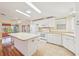 Open kitchen layout with white appliances, kitchen island, tile flooring and great natural lighting at 724 Blackburn Blvd, North Port, FL 34287