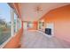 Spacious sunroom featuring orange walls, sliding glass doors, a modern fireplace and tiled flooring at 724 Blackburn Blvd, North Port, FL 34287