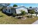 Cozy single-story home with a covered carport, tropical plants, and well-manicured lawn at 861 Seabrooke Dr, Englewood, FL 34223
