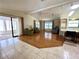 Bright living room with hardwood floors, ceiling fan, and sliding doors to an enclosed sunroom at 861 Seabrooke Dr, Englewood, FL 34223