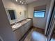 Bright bathroom featuring double sinks, a vanity with a granite countertop, and wood-look flooring at 1022 Waterside St, Port Charlotte, FL 33952