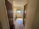 Hallway leading to bright bathroom with wood-look tile and a vanity with sink and window at 1022 Waterside St, Port Charlotte, FL 33952