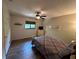 Comfortable bedroom with wood-look floors, a ceiling fan, and natural light from the window at 1022 Waterside St, Port Charlotte, FL 33952