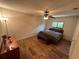 Bedroom with wood floors, ceiling fan, lamp, dresser, queen bed and window at 1022 Waterside St, Port Charlotte, FL 33952