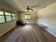 Well-lit bedroom with wood floors, several windows, ceiling fan, and stylish chaise lounge at 1022 Waterside St, Port Charlotte, FL 33952