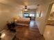 Cozy bedroom features wood-look flooring, ceiling fan, and natural light from the window at 1022 Waterside St, Port Charlotte, FL 33952