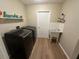 Well-lit laundry room featuring modern washer and dryer, with a utility sink and built-in shelving at 1022 Waterside St, Port Charlotte, FL 33952