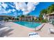 Community pool with plenty of lounge chairs for relaxing under the palm trees at 1080 Bal Harbor Blvd # 10C, Punta Gorda, FL 33950