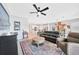 Bright living room featuring a ceiling fan, comfortable black leather sofa, and elegant area rug at 11359 Burgundy, Venice, FL 34293