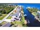Waterfront home aerial view with a dock and lift, solar panels, landscaping, and canal access at 12676 Bacchus Rd, Port Charlotte, FL 33981