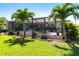 View of the back of the home showing the pool enclosure and backyard at 12676 Bacchus Rd, Port Charlotte, FL 33981