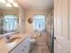 Well-lit bathroom featuring a sink vanity, toilet, and shower with patterned curtain at 12676 Bacchus Rd, Port Charlotte, FL 33981