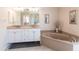 Elegant bathroom showcasing a double vanity, corner soaking tub, and neutral tile flooring at 12676 Bacchus Rd, Port Charlotte, FL 33981