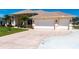 Concrete driveway with space for three cars leading up to a well-maintained home with lush lawn at 12676 Bacchus Rd, Port Charlotte, FL 33981